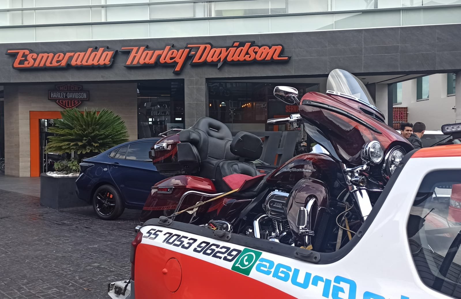 Traslado de una motocicleta de turismo frente a una agencia Harley-Davidson